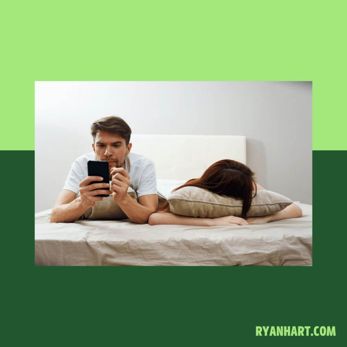 Husband looking at phone in bed