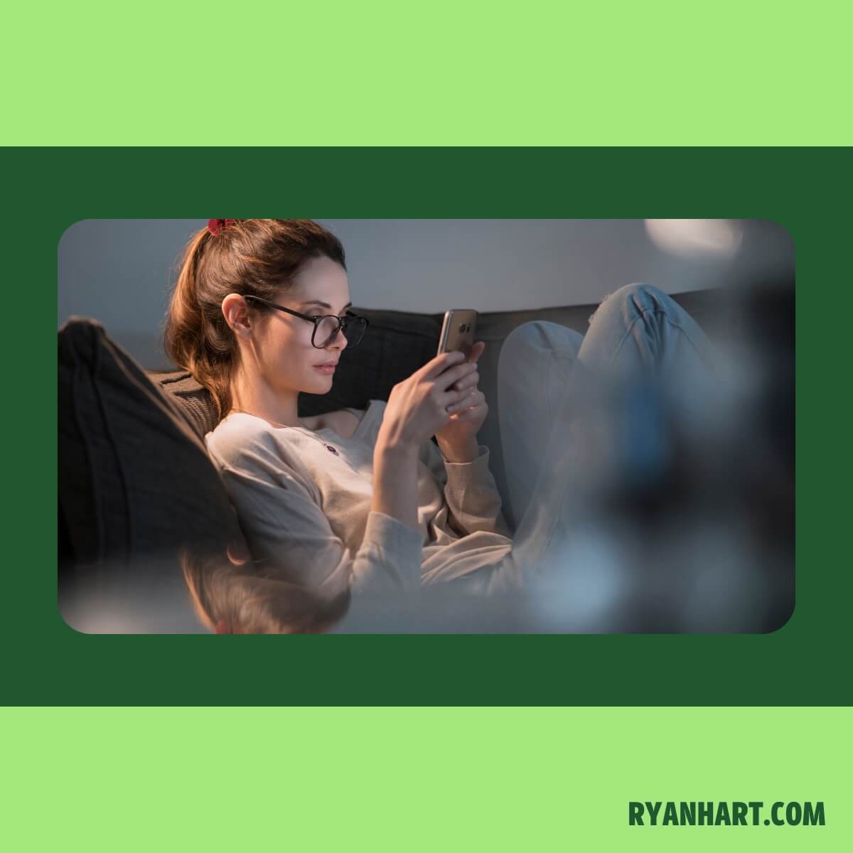 Woman looking at phone while sitting on couch