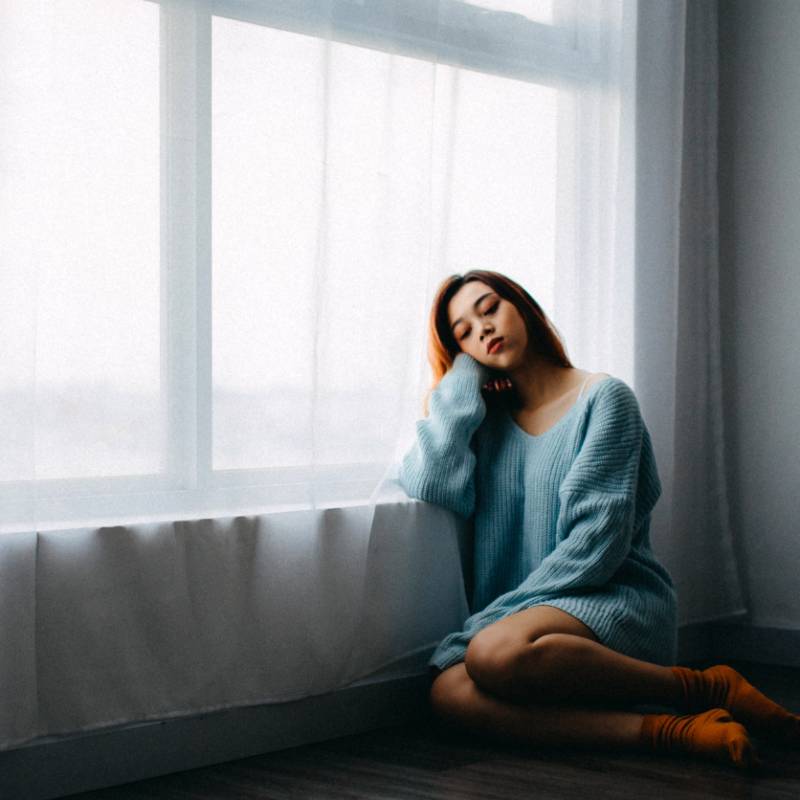 Woman Sitting Alone by Window