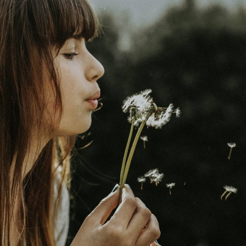 Woman holding dandelion