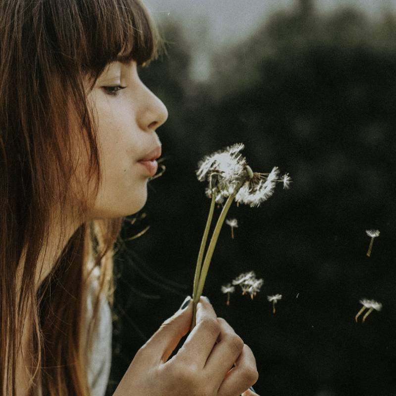 Woman holding dandelion